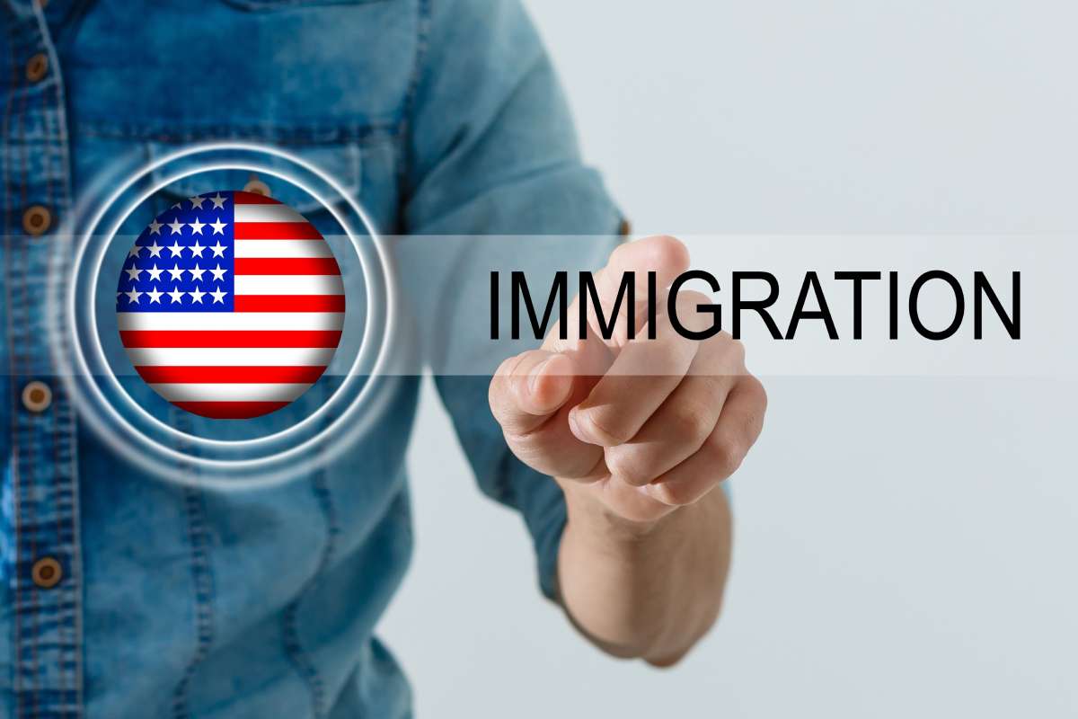 Immigration concept with the US flag and a person pushing a virtual button