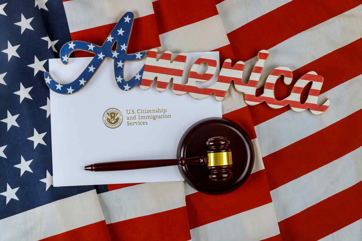 America sign and gavel on top of US flag and immigration document