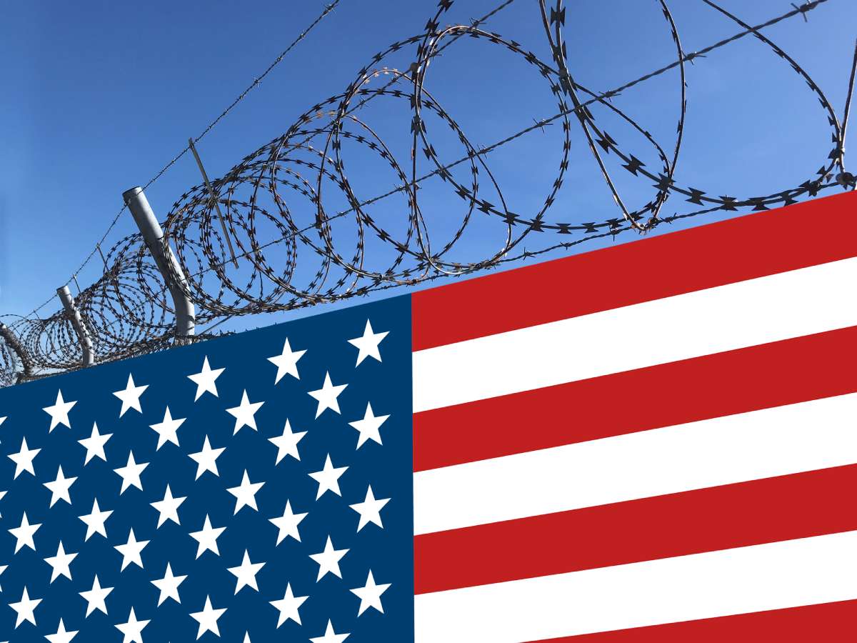 Barbed wire fence covered with USA flag
