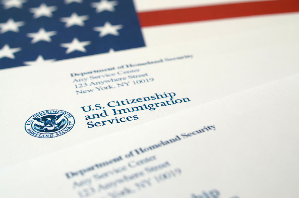 Envelopes with letter from USCIS on United States flag from Department of Homeland Security