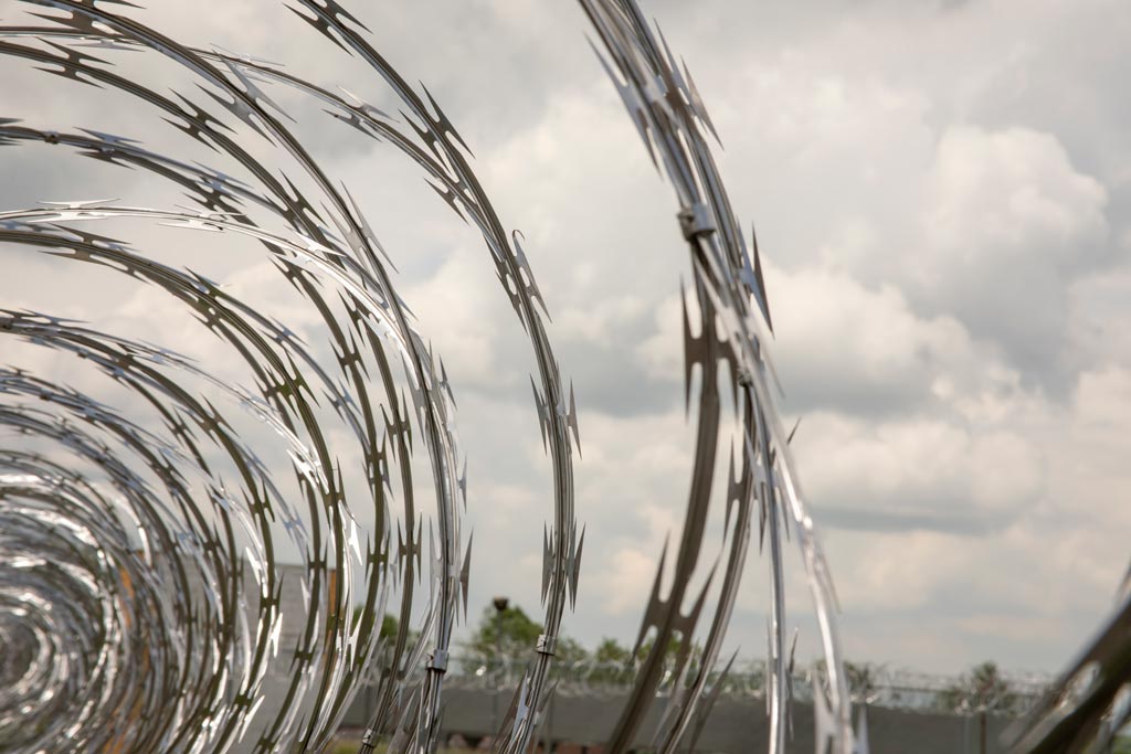 Close up of coiled razor wire on metal fence