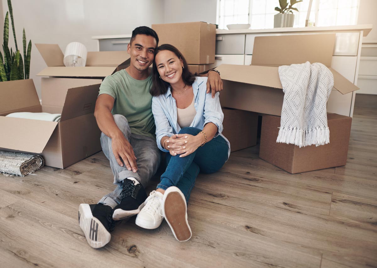 couple and happy in new home with boxes for moving in