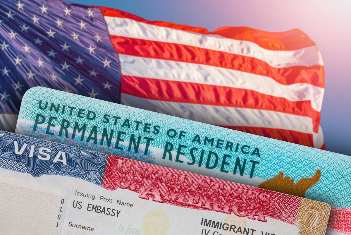 Closeup of green card and visa with US flag as background